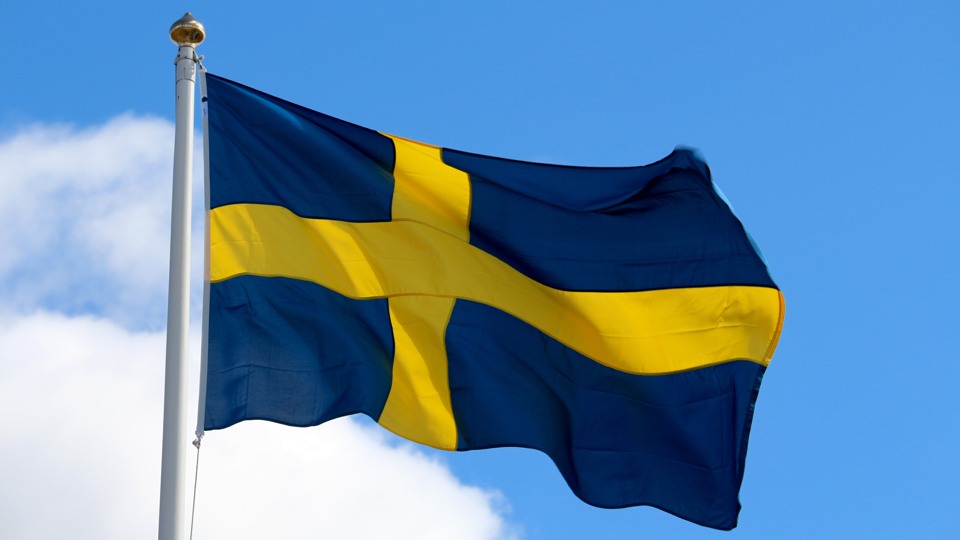 Svenska flaggan gul och blå flaggar i vinden