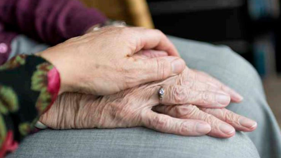 Yngre hand håller över ett äldre par händer.