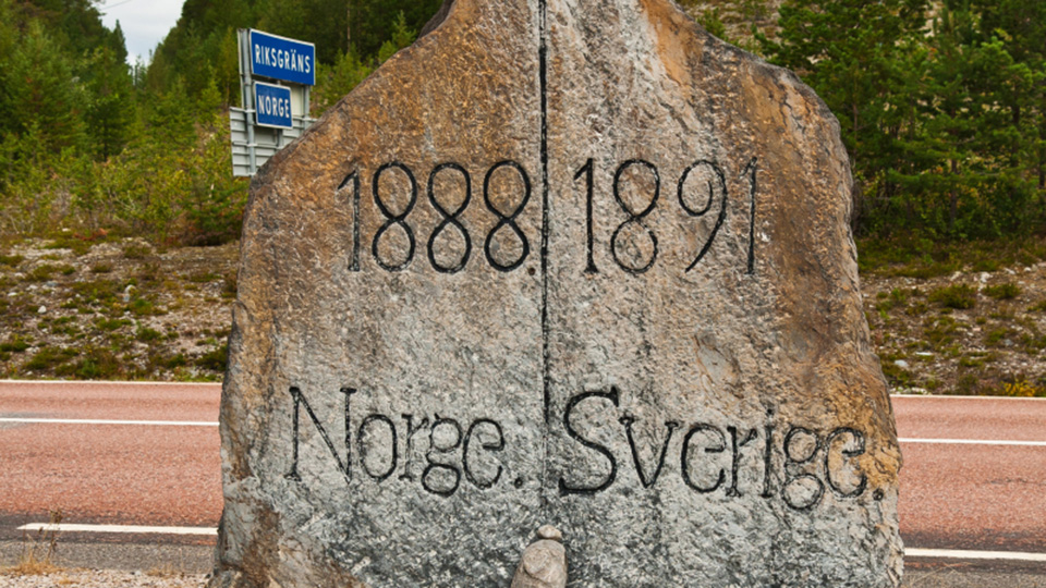 Sten vid sidan av väg väg vid gränsen mellan Sverige och Norge. Text inristat på stenen 1888/1891 Norge/Sverige