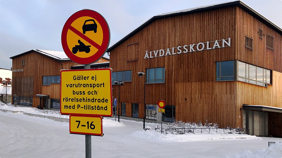 Skylt med förbud mot trafik med annat motordrivet fordon än moped klass II, varutransport, buss och rörelsehindrade med p-tillstånd utanför Älvdalsskolan en vinterdag.