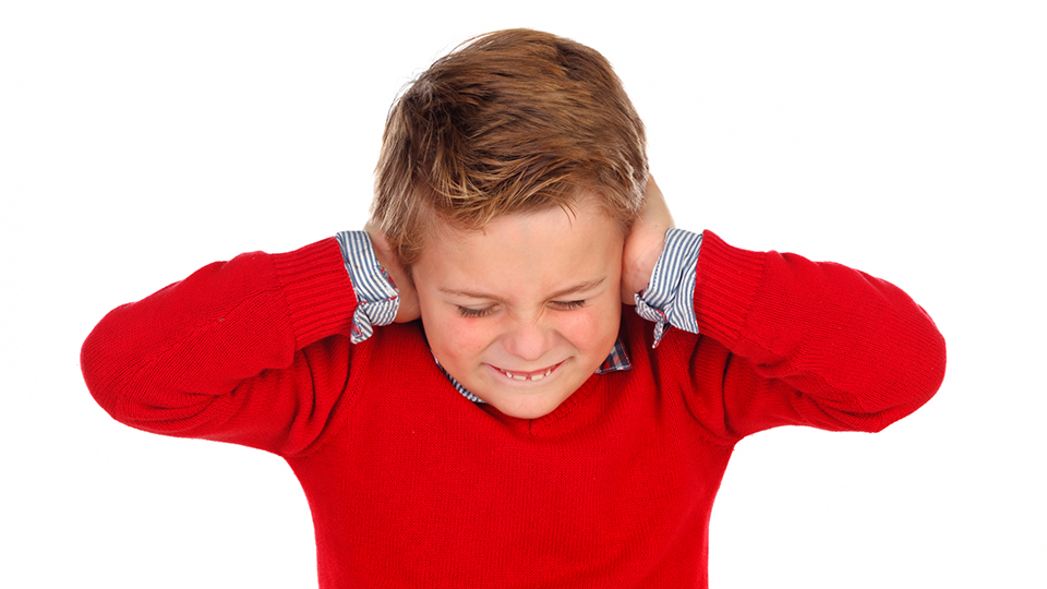 Barn som håller för öronen på grund av störande buller