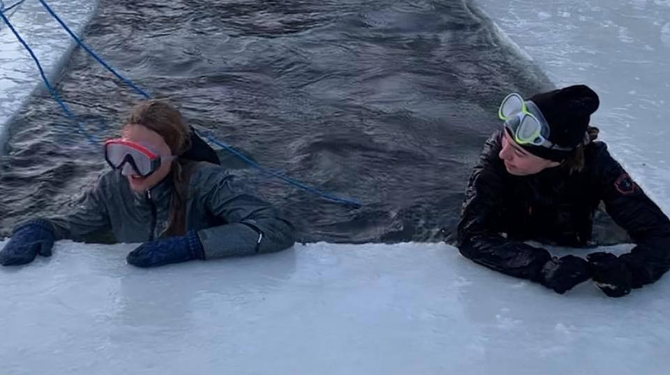 Två elever befinner sig, under säkra former, i en isvak. En del av utbildningen i issäkerhet för elever i Älvdalens kommun.