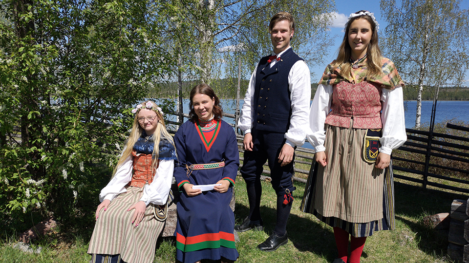 Fyra dräktklädda ungdomar på gammelgården i Särna.