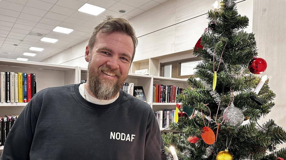 Thomas Kjellson som blir tillförordnad kommundirektör på Älvdalens kommun ståendes på biblioteket intill en julgran
