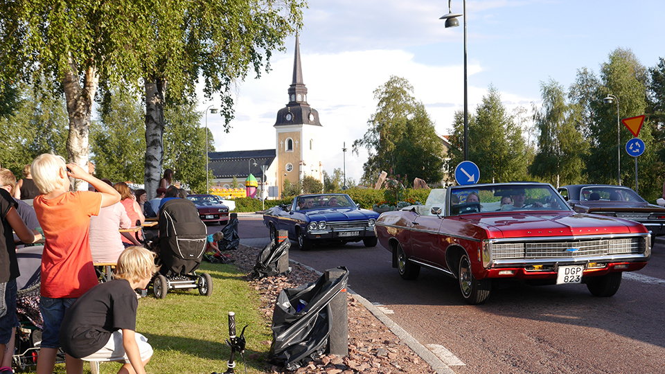 Många är ute och tittar på fina bilar som cruisar vid rondellen i Älvdalen under Musik och motorfestivalen