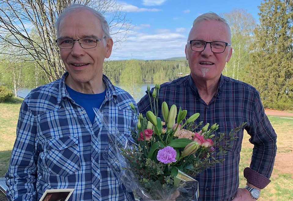 Kommunalrådet Kjell Tenn uppvaktar årets kulturpristagare Elis Eriksson med blommor utomhus.